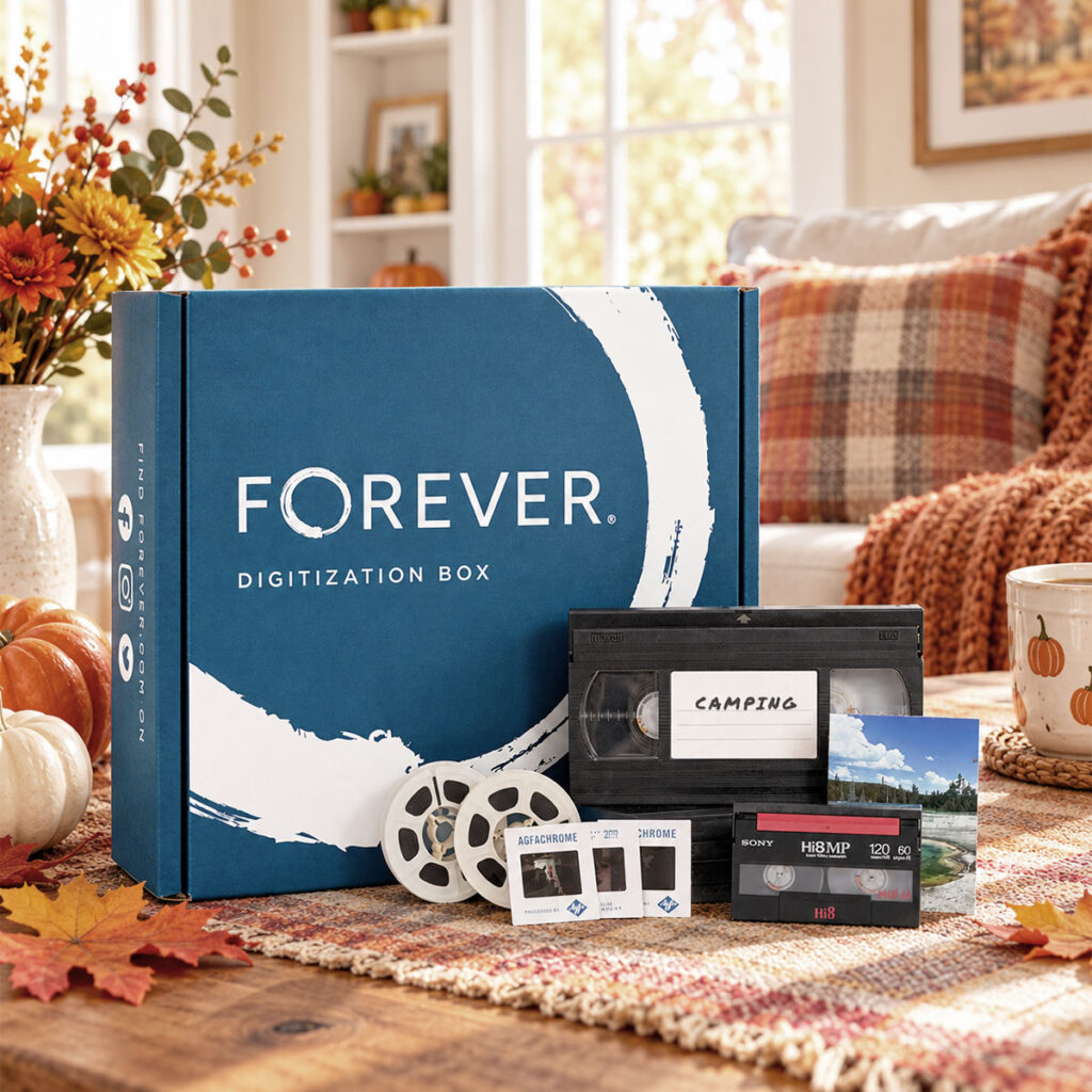 FOREVER Digitization Box with VHS tape, film reels, slides, and photos on a cozy fall table